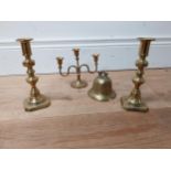 Three brass candlesticks and brass bell {18 cm, 14 cm & 7 cm H}.