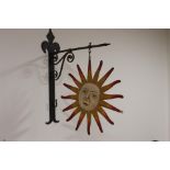 Sunburst metal hanging sign mounted on metal bracket {54 cm H x 15 cm W x 38 cm D}.