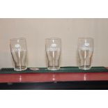 Set of three Guinness advertising pint glasses in original box {15 cm H x 5 cm Dia.}.