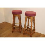 Pair of high oak bar stools with upholstered seats and brass foot rests. { 75 cm H x 33 cm Diam}.