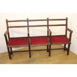 Oak three seater bench with red velvet upholstered seats {92 cm H x 150 cm W x 39 cm D}.