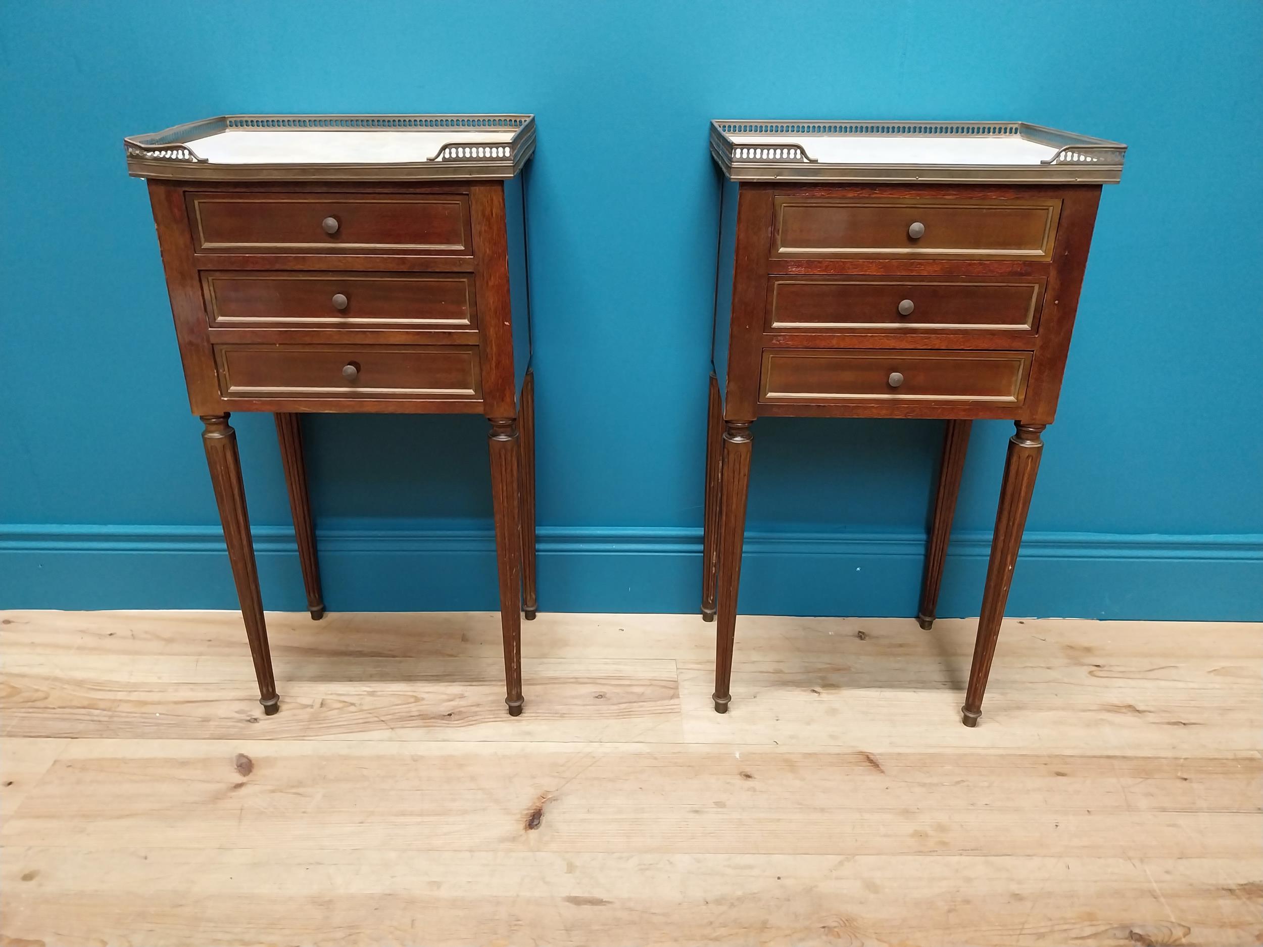 Pair of 19th C. mahogany and brass bedside lockers with inset marble top and three drawers raised on