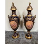 Large pair of decorative hand painted ceramic lidded urns with brass mounts {131 cm H}.