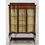 Edwardian mahogany inlaid shaped front display cabinet with one glazed panelled door raised on