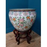 Large Oriental ceramic planter decorated with pomegranates, flowers and carp on carved mahogany