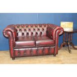 Deep buttoned red leather two seater Chesterfield soda raised on bun feet {H 84cm x W 150cm x D