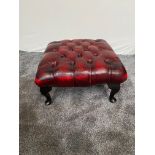 Deep buttoned ox blood red leather footstool raised on cabriole legs. {32 cm H x 59 cm W x 59 cm