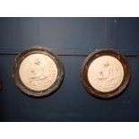 Pair of round black marble and plaster wall plaques with cherub scene {Dia 42cm}.