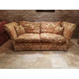 Decorative cream and red upholstered two seater couch with cushions, with drop down sides in the
