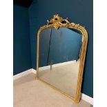 Victorian decorative gilt overmantle mirror surmounted with foliage and with bevelled plate. { 180