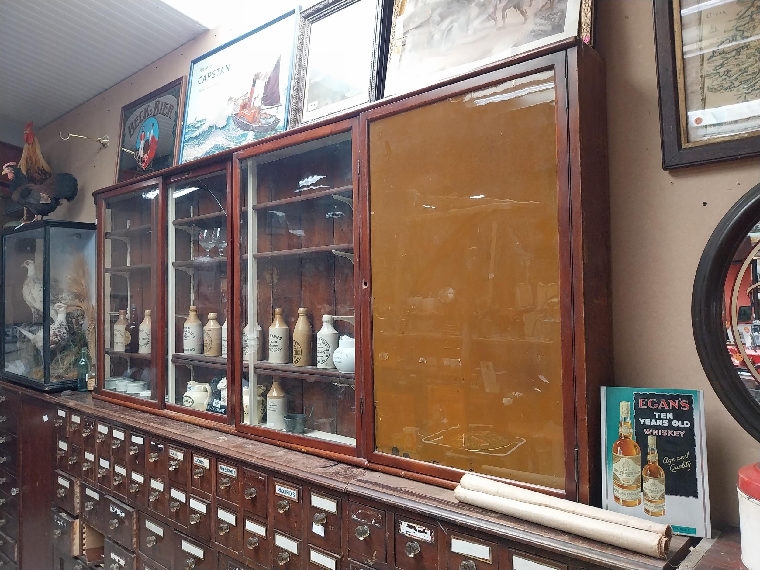 Early 20th C mahogany wall mounted glazed chemist cabinet {102cm H x 252cm W x 36cm D} - Image 2 of 2