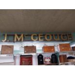 J McGeough shop sign {34 cm H x 302 cm W}.