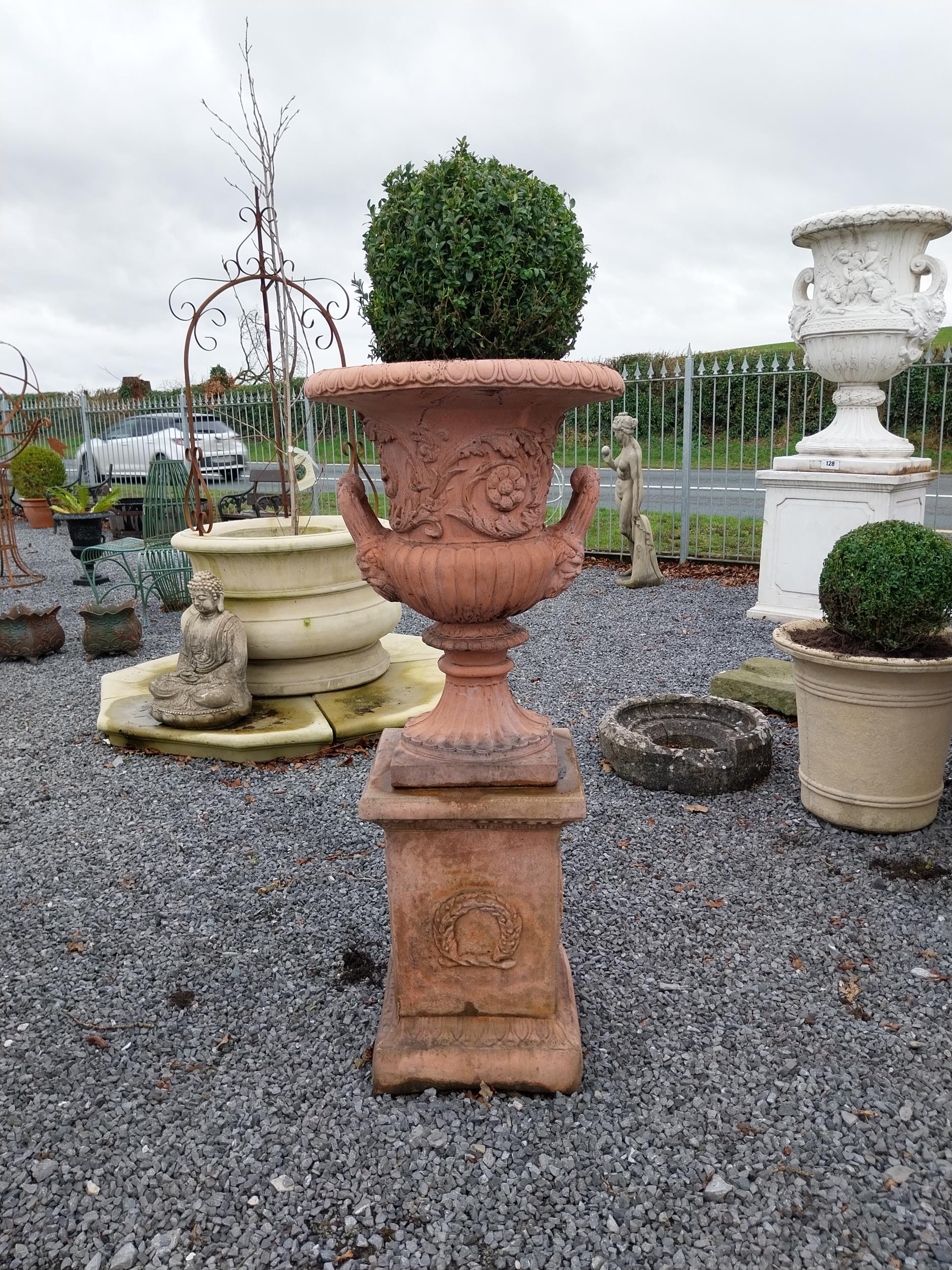 Pair of moulded stone terracotta urns with floral and lion's masks decoration on pedestal in the - Image 2 of 4