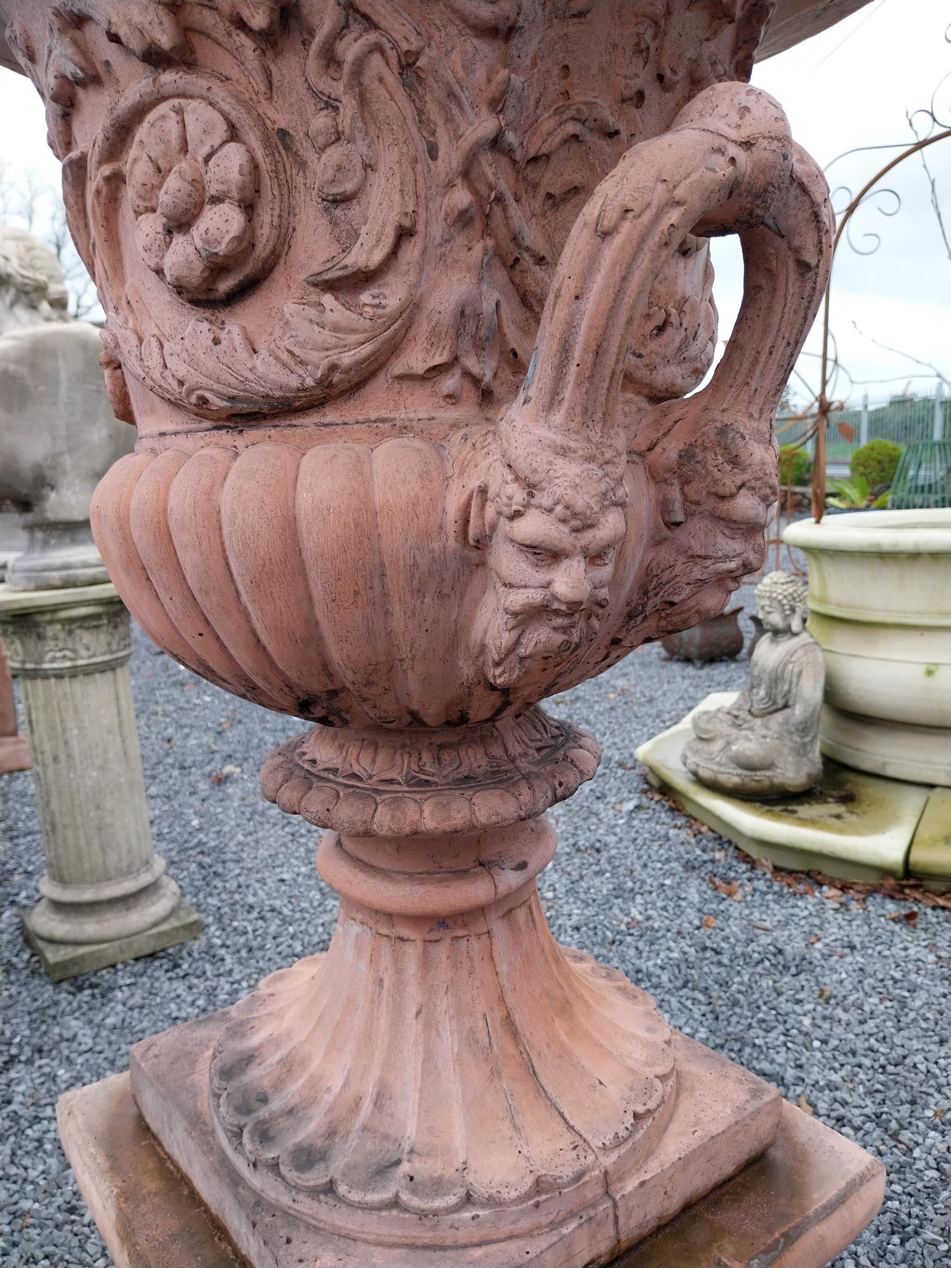 Pair of moulded stone terracotta urns with floral and lion's masks decoration on pedestal in the - Image 4 of 4