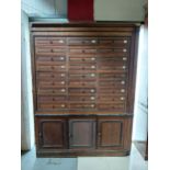 Early 20th C. oak office cabinet with bank of twenty seven drawers above three blind doors in need
