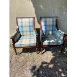 Pair of mahogany and upholstered arm chairs raised turned legs in the Regency style.