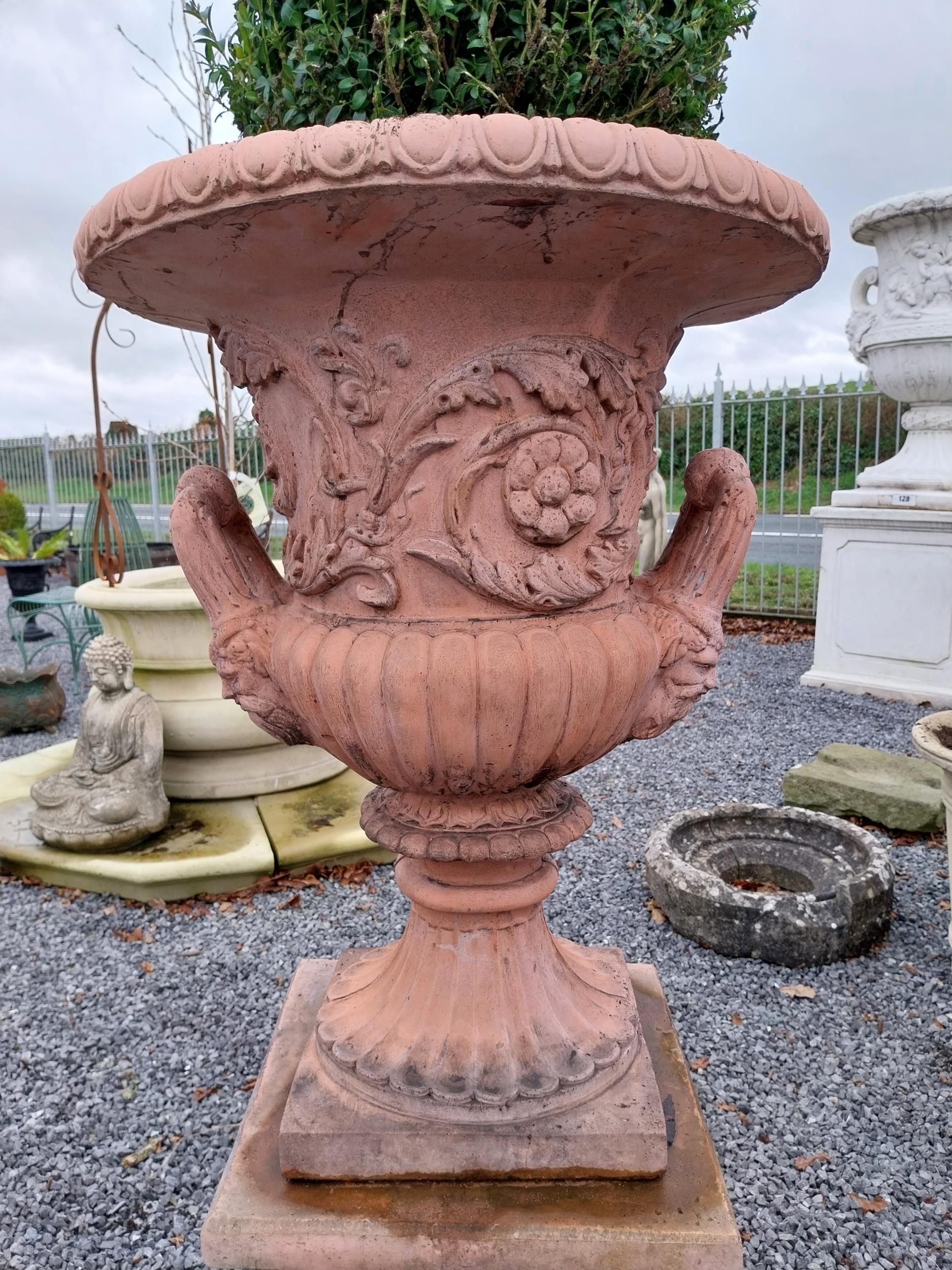 Pair of moulded stone terracotta urns with floral and lion's masks decoration on pedestal in the - Image 3 of 4