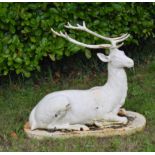 Cast iron model of seated Deer on oval plinth {90 cm H x 105 cm W x 45 cm D}.