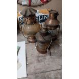 Three copper and metal ship's lanterns. {29 cm H to 22 cm H}.