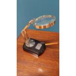 Chrome and ebonised table magnifying glass {18 cm H x 18 cm W x 9 cm D}.