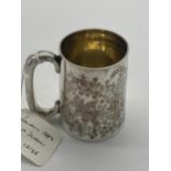 English silver mug decorated with foliage. Hallmarked in London 1884. Maker George Maudsley Jackson.