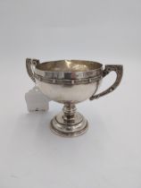 Irish silver trophy cup, the round body with two handles decorated with Celtic design inscribed