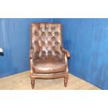 Brown leather deep buttoned armchair raised on turned legs {H 95cm x W 85cm x D 65cm }.