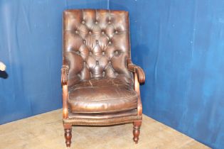 Brown leather deep buttoned armchair raised on turned legs {H 95cm x W 85cm x D 65cm }.