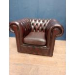 Red leather deep buttoned tub chair raised on casters {H 72cm x W 100cm x D 85cm }.