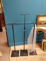 Three adjustable metal shop display stands. {82 cm H x 28 cm W x 28 cm D}.