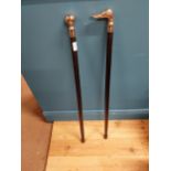 Two walking sticks with Duck head finial and ball finial. {93 cm H}.