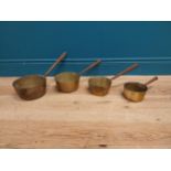 Set of four graduated brass and metal saucepans. {21 cm H x 44 cm W x 20 cm D} to {8 cm H x 28 cm