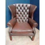 Brown leather deep button wingback chair raised on square legs {H 95cm x W 85cm x D 65cm }.