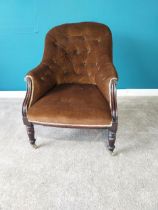 Victorian mahogany and upholstered arm chair raised on turned legs and brass castors.