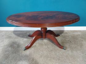 Mahogany oval coffee table on turned column with four outswept feet. {53 cm H x 110 cm W x 66 cm