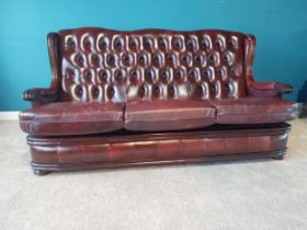 Deep buttoned leather and mahogany three seater sofa {95 cm H 178 cm W 74cm D}.