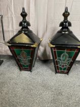 Pair of metal and painted brass wall lanterns with leaded stain glass panels and brackets.