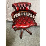 Ox blood leather deep buttoned and mahogany swivel desk chair raised on four outswept legs and