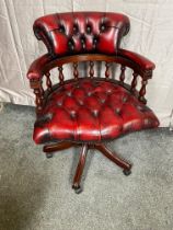 Ox blood leather deep buttoned and mahogany swivel desk chair raised on four outswept legs and