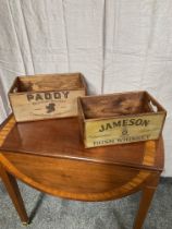 Two wooden advertising boxes - Jameson Whiskey and Paddy Whiskey.