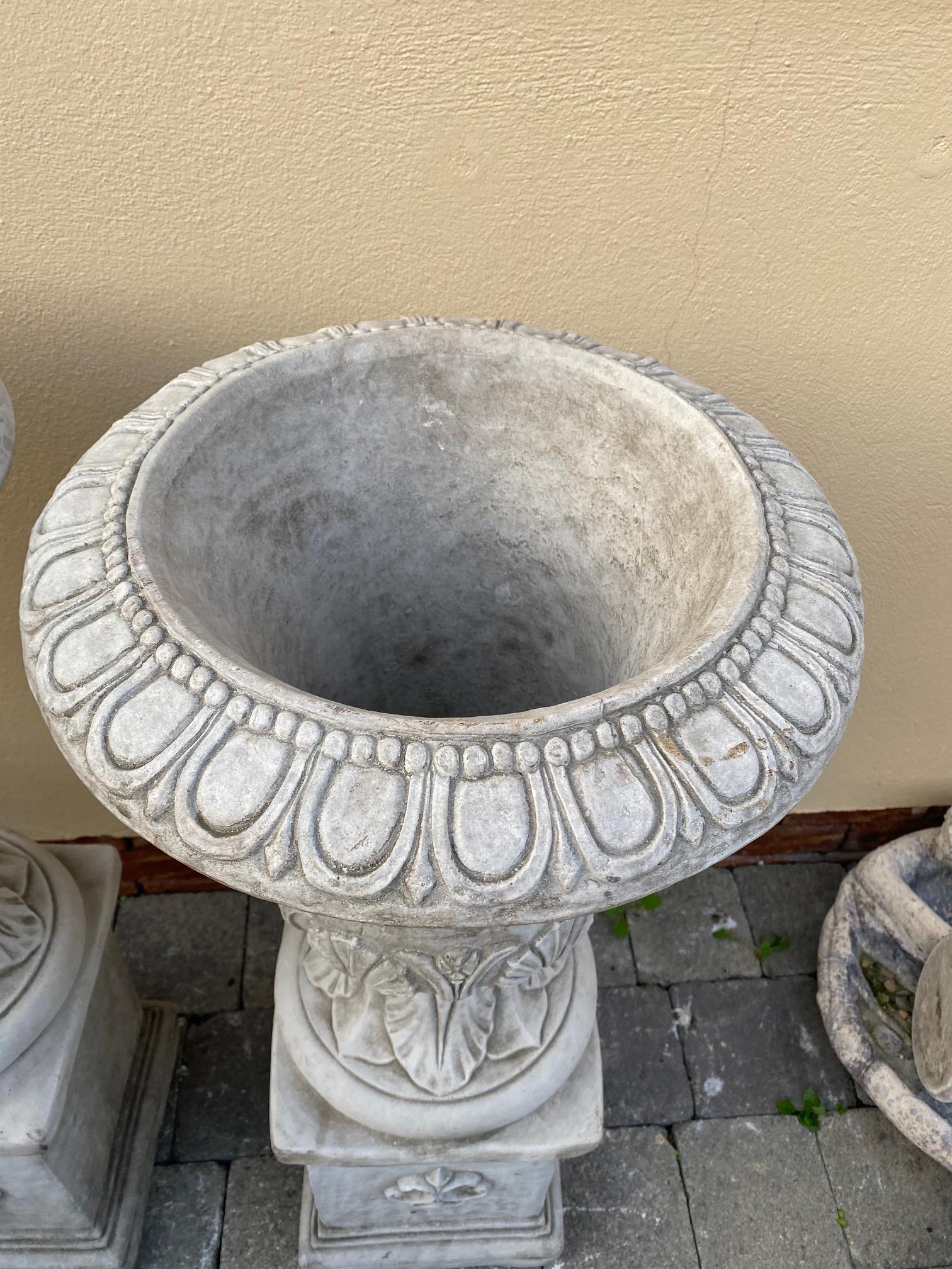 Pair of stone urns with leaf decoration on square pedestal bases. {96 cm H x 41 cm Dia.}. - Image 3 of 5