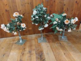 Three artificial flowers mounted on metal stands {96 cm H x 47 cm Dia. And 90 cm H x 57 cm Dia.}.