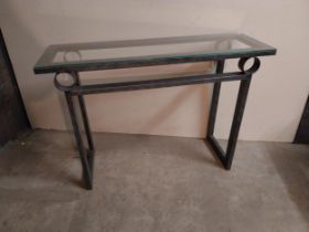 Bronzed metal designer side table with glass top {78 cm H x 110 cm W x 35 cm D}.