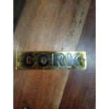 Cork brass wall sign {H 4cm x W 15cm }.