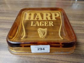 Harp Lager amber glass advertising ashtray. {4 cm H x 15 cm W x 15 cm D}.