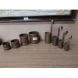 Two sets of copper and brass measures {7 cm