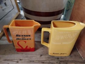 Two Benson and Hedges ceramic water advertising jugs. {18 cm H x 19 cm W x 7 cm D} and {16 cm H x 18