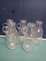 Five old milk bottles with handles