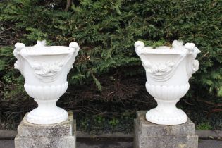 Pair of composite stone urns decorated with swags and tails- bases not included