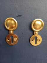 Pair of covered Victorian brass escutcheons. {D 3cm}.